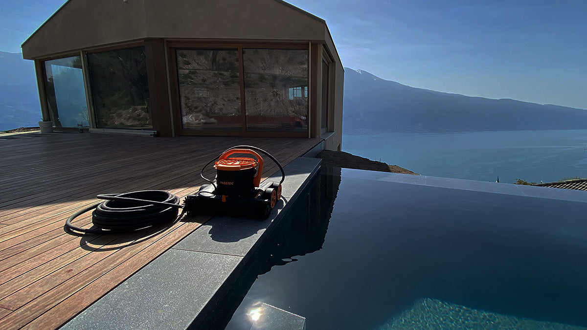 Der TOSSTEC Biopoolroboter TT-RB neben Pool mit Meer im Hintergrund